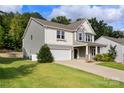 Two-story home showcasing a two-car garage, lush lawn, and inviting entryway, perfect for suburban living at 3212 Gilroy Dr, Fort Mill, SC 29707