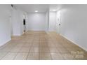 Spacious living room with tile flooring, closet, and view to the kitchen at 326 Orchard Trace Ln # 3, Charlotte, NC 28213