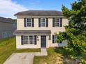 Inviting two-story home with light yellow siding, black shutters, and a classic design at 3527 Crestridge Dr, Charlotte, NC 28217