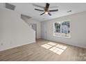 Bright living room with hardwood floors, a ceiling fan, and natural light streaming through the windows at 3527 Crestridge Dr, Charlotte, NC 28217