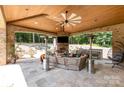 Covered outdoor living space with fireplace, built-in grill, ceiling fan, and comfortable seating at 4005 Capullo Ct, Matthews, NC 28104