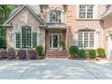 Inviting front entrance with a decorative glass door, manicured landscaping, and brick steps at 4075 Crepe Ridge Dr, Denver, NC 28037