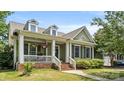 Quaint two-story house with dormer windows and an inviting front porch with hanging flower baskets at 4115 Birkshire Hts, Fort Mill, SC 29708