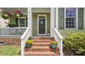 Close-up of the home's entrance with brick steps, potted plants, and decorative door wreath at 4115 Birkshire Hts, Fort Mill, SC 29708