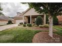 Beautiful home with manicured landscaping, brick facade, covered front porch, and mature shade trees at 4518 Courtyard Blvd # 4, Harrisburg, NC 28075