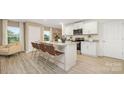 Open kitchen with island seating, stainless appliances, and light wood floors in neutral tones at 4689 Fanning Rd, Hickory, NC 28602