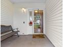 View of the front porch featuring an outdoor bench, accent flowers, and a glass storm door at 510 Sw Viking Sw Pl, Concord, NC 28025