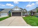Charming home with a stone and siding exterior, well-manicured lawn, and a two-car garage at 6277 Raven Rock Dr, Denver, NC 28037