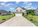 Well-maintained two-story home featuring a spacious driveway, manicured landscaping, and a welcoming front porch at 635 Scarlet Leaf Ln, Oakboro, NC 28129