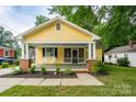 Inviting yellow home with a classic front porch, rocking chairs, and meticulously landscaped front yard at 660 Ideal Way, Charlotte, NC 28203