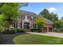Charming brick home with black shutters, a manicured lawn, and a two-car garage at 6916 Cameron Glen Dr, Charlotte, NC 28210