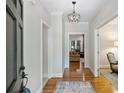 Inviting entryway with hardwood floors, elegant lighting fixture, and views into the living spaces at 7117 Cobblecreek Dr, Weddington, NC 28104