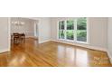 Bright living room featuring hardwood floors, a large window and an open layout into dining area at 7117 Cobblecreek Dr, Weddington, NC 28104