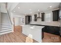 Open concept kitchen features stainless steel appliances, an island and dark cabinets at 716 Flare Dr, Tega Cay, SC 29708