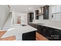 Bright kitchen has a large island, dark cabinets, and stainless steel range hood at 716 Flare Dr, Tega Cay, SC 29708