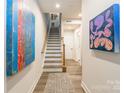 Bright entryway featuring contemporary artwork, a wooden staircase, and neutral tones at 819 Anderson St, Charlotte, NC 28205