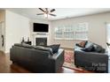 Comfortable living room with a fireplace, large windows, and hardwood flooring, ideal for Gathering gatherings at 9285 Swimming Dr, Harrisburg, NC 28075