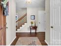 Inviting foyer featuring hardwood floors, a staircase, and a charming accent table at 9928 Raddington Ln, Charlotte, NC 28269