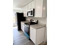 Modern kitchen featuring stainless steel appliances, white cabinets, and light countertops at 1012 4Th St, Statesville, NC 28677