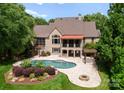 Stunning backyard oasis with inground pool, stone patio, pergola, and lush landscaping at 1108 Shinnecock Ln, Waxhaw, NC 28173