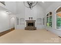 Bright living room with stone fireplace, built-in shelves, and large windows at 1108 Shinnecock Ln, Waxhaw, NC 28173