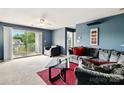 Cozy living room with neutral carpet, comfortable sofa, glass table, and outdoor balcony access at 1134 Plaza Walk Dr, Charlotte, NC 28215