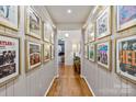 Unique hallway featuring framed Beatles posters and gleaming hardwood floors at 1172 Queens Rd, Charlotte, NC 28207
