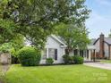 Inviting single-story house with a gray exterior, black shutters, and manicured front yard at 12013 Dolomite Dr, Pineville, NC 28134