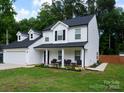 Well-maintained two-story home with a covered front porch, attached garage and manicured lawn at 12150 Plover Dr, Charlotte, NC 28269
