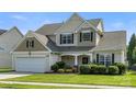 Charming two-story home featuring a well-manicured lawn, attached garage, and inviting front porch at 12312 Mcallister Park Dr, Charlotte, NC 28277