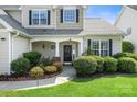 Inviting front porch with decorative wreath, manicured landscaping, and a well-maintained lawn at 12312 Mcallister Park Dr, Charlotte, NC 28277