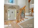 Welcoming foyer with gleaming hardwood floors, staircase, and decorative details around the front door at 129 N Audubon Ave, Mooresville, NC 28117