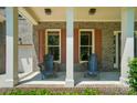 Inviting front porch with brick accents, sturdy columns, and comfortable seating for relaxing outdoors at 129 N Audubon Ave, Mooresville, NC 28117