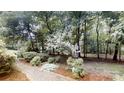Landscaped backyard with a brick pathway winding through lush greenery and mature trees at 139 Cricket Creek Dr, Cherryville, NC 28021