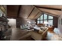 Spacious living room with high ceilings, wood paneling, and a large window overlooking the property at 139 Cricket Creek Dr, Cherryville, NC 28021