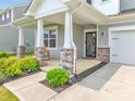 Inviting front porch detailed with stone-accented columns and seating area creating a warm, welcoming entrance at 14734 Rivergate Pkwy, Charlotte, NC 28273