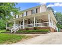 Inviting two-story home with a spacious front porch, brick accents, and well-maintained landscaping at 1543 Newfound Hollow Dr, Charlotte, NC 28214