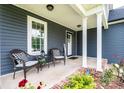 Inviting front porch with two wicker chairs and a welcome sign by the black front door at 201 S 5Th Ave, Maiden, NC 28650