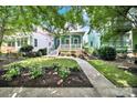Charming two-story home with a covered front porch and landscaped garden on a sunny day at 228 Coneflower Pl, Fort Mill, SC 29708