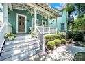 Inviting covered front porch with white railings, potted plants, and hanging ferns at 228 Coneflower Pl, Fort Mill, SC 29708