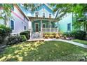 Charming blue two-story home with a welcoming front porch and landscaped yard with plants at 228 Coneflower Pl, Fort Mill, SC 29708