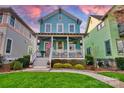 Charming blue two-story home with a welcoming front porch and landscaped yard with plants and flowers at 228 Coneflower Pl, Fort Mill, SC 29708