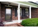 Inviting front porch features brick accents, black shutters, and a classic bench at 2817 Long Cir # 1, Iron Station, NC 28080