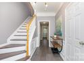 Inviting entryway featuring tile flooring, a staircase, and neutral wall colors at 2945 Duvalla Ave, Charlotte, NC 28209