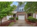 Attractive townhome showcasing brick accents, an attached garage, and welcoming landscaping with shade trees at 3237 Yarmouth Ln, Gastonia, NC 28056