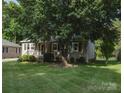Exterior view of a well-kept home with mature trees, a welcoming porch, and green shutters at 332 Daybrook Dr, Landis, NC 28088