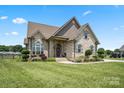 Charming brick home with a manicured lawn, complemented by mature trees and a spacious driveway at 3340 Emerald Pointe Ct, Monroe, NC 28110
