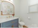 Stylish half bathroom with modern fixtures, a decorative mirror, and a clean, bright design at 4305 Twenty Grand Dr, Indian Trail, NC 28079