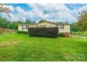 Nice view of a backyard with a lush green lawn and mature shrubbery around the house at 4373 Wentz Rd, Maiden, NC 28650