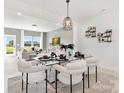 Bright dining room with modern chandelier over glass table and views into the living room at 492 Switch St # 82 Ty, York, SC 29745